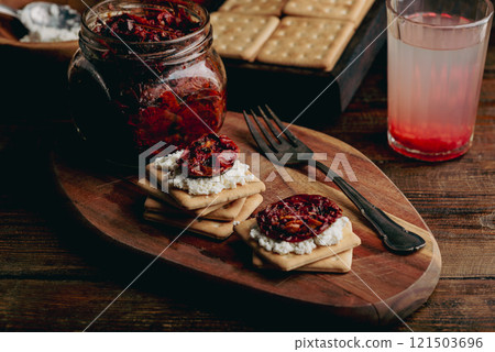 Homemade sun-dried tomatoes and cream cheese on crackers 121503696