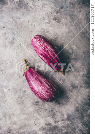 Two purple eggplants on concrete backdrop 121503717