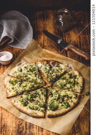 Sliced pizza with broccoli, pesto and cheese Sliced pizza with broccoli, pesto and cheese 121504014