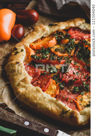 Baked tomato galette on baking paper 121504040