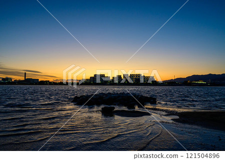 A seaside scene with the silhouette of the Yaichi apartment building. Photographed at Kohroenhama Beach in Nishinomiya City. A seaside scene with the silhouette of the Yaichi apartment building. Photographed at Kohroenhama Beach in Nishinomiya City. 121504896