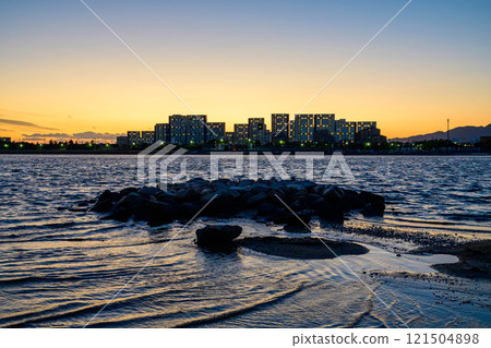 A seaside scene with the silhouette of the Yaichi apartment building. Photographed at Kohroenhama Beach in Nishinomiya City. 121504898