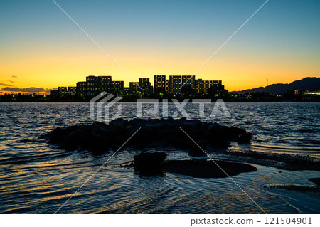 A seaside scene with the silhouette of the Yaichi apartment building. Photographed at Kohroenhama Beach in Nishinomiya City. A seaside scene with the silhouette of the Yaichi apartment building. Photographed at Kohroenhama Beach in Nishinomiya City. 121504901