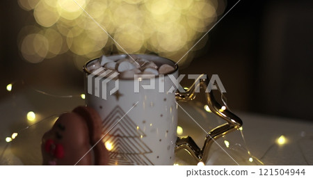 A woman puts marshmallows in a glass of cocoa. Christmas, New Year concept background. 121504944
