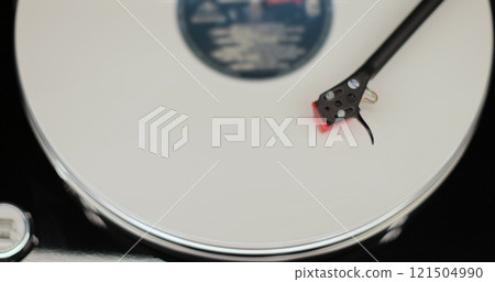 Close-up of a vinyl record spinning on a retro turntable from top view. Classic vinyl record player. Close-up of a vinyl record spinning on a retro turntable from top view. Classic vinyl record player. 121504990