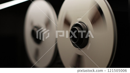 Reel to reel tape recorder playing. Rotating vintage music player close up. Retro tape. Old school concept. 121505006