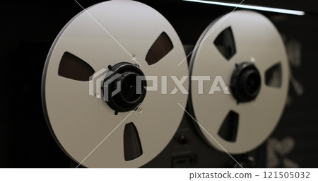 Reel to reel tape recorder playing. Rotating vintage music player close up. Retro tape. Old school concept. 121505032
