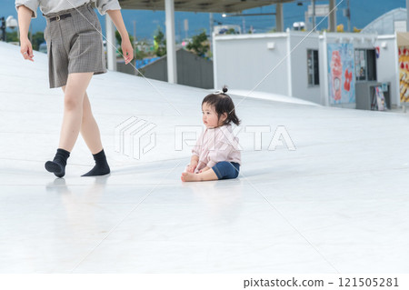 [Mother and infant sitting on giant playground equipment] 121505281