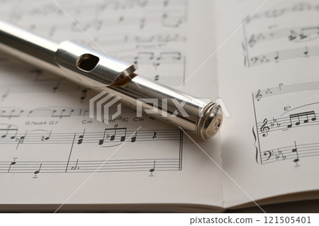 放置在樂譜上的長笛頭管的特寫 121505401