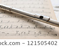 放置在舊樂譜上的長笛頭管的特寫 121505402