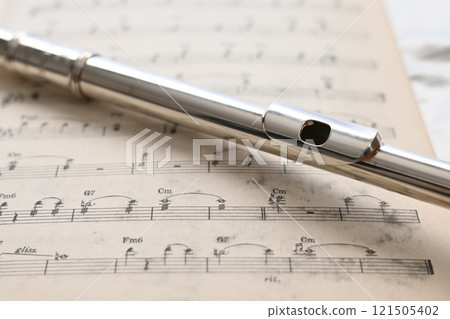 放置在舊樂譜上的長笛頭管的特寫 121505402