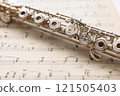 一根銀笛，上面有一把環形鑰匙，放在舊樂譜上 121505403