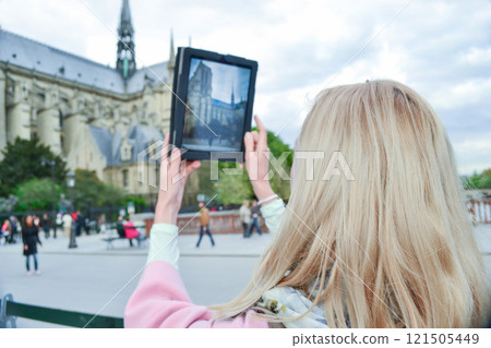 Blonde woman tourist in Paris making selfie with Notre-Dame Blonde woman tourist in Paris making selfie with Notre-Dame 121505449