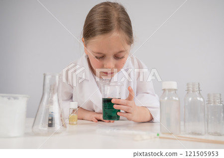 Caucasian girl doing chemical experiments on a white background.  121505953