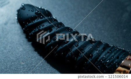 Black silicone vibrator in water. Circles on water around sex toy. Black silicone vibrator in water. Circles on water around sex toy. 121506014