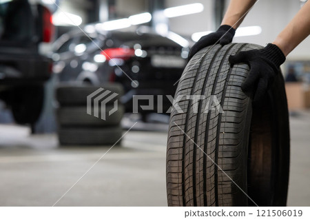 Man holding old car tire. Close up of mechanic's hands with wheel. Man holding old car tire. Close up of mechanic's hands with wheel. 121506019