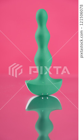 Green anal beads on pink mirror background.  Green anal beads on pink mirror background.  121506078