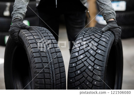 Mechanic keeps new summer and winter car tires in the garage. Comparison of wheels for different seasons.  121506080