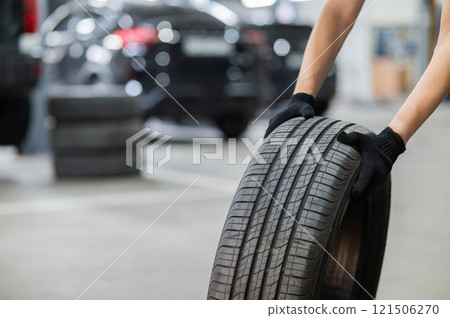 Man holding old car tire. Close up of mechanic's hands with wheel. Man holding old car tire. Close up of mechanic's hands with wheel. 121506270