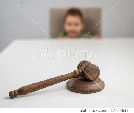 Little boy behind judge's gavel. Little boy behind judge's gavel. 121506331