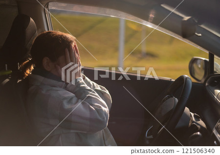 Caucasian woman cries while driving.  121506340