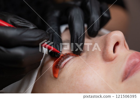 Caucasian woman undergoing eyelash lamination procedure.  121506395