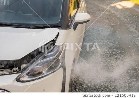 Smoke is coming from under the hood of the car. Smoke is coming from under the hood of the car. 121506412