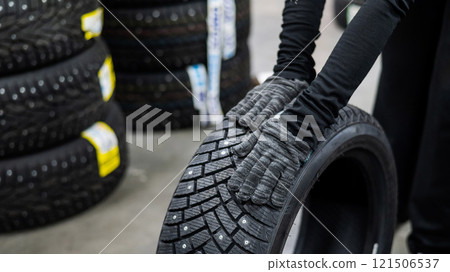Mechanic keeps new studded car tires in garage. Mechanic keeps new studded car tires in garage. 121506537