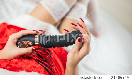 Caucasian woman in santa claus costume and stockings lies on bed with sex toy. Caucasian woman in santa claus costume and stockings lies on bed with sex toy. 121506549