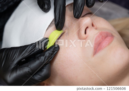 The master lays down the roller before the eyelash lamination procedure. The master lays down the roller before the eyelash lamination procedure. 121506606