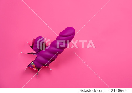 Raspberry sex toy sticks out of pink paper background. Copy space. Raspberry sex toy sticks out of pink paper background. Copy space. 121506691