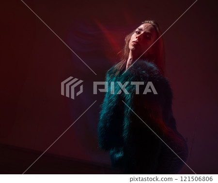 A young woman dances contemporary dances in blue and red light. Long exposure photo.  121506806