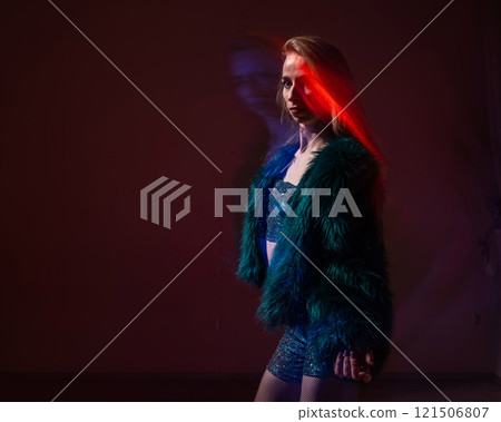 A young woman dances contemporary dances in blue and red light. Long exposure photo.  121506807