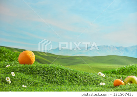 The photograph of a hill scene with a green lawn, was taken from front view. Blank space on grass for product placing, decorated with fresh fruits and tiny flowers 121507433