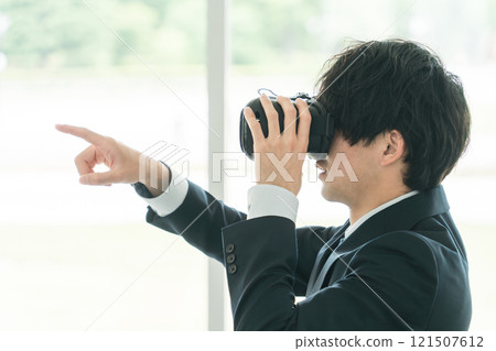 戴著 VR 護目鏡並體驗虛擬實境/元宇宙的商人/培訓師 121507612