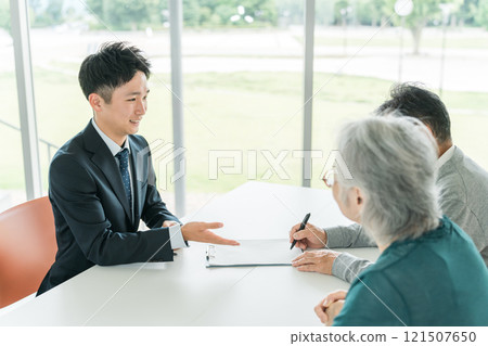 老夫婦和商人（理財規劃師）簽署文件、合約和申請表 121507650