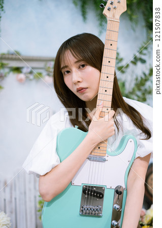 Long-haired young woman with an electric guitar Long-haired young woman with an electric guitar 121507838