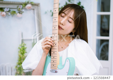 拿著電吉他的長髮年輕女子 121508447