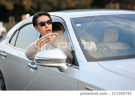 Middle-aged man getting irritated while driving Middle-aged man getting irritated while driving 121508791