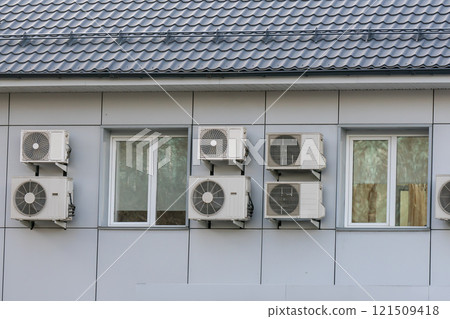 Air conditioner coolers on the wall of the house around the windows. 121509418