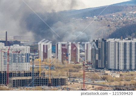 Black smoke from a fire in the city. 121509420