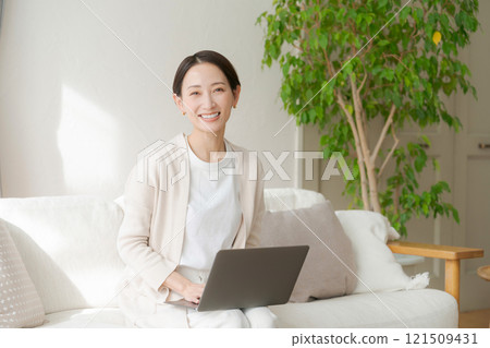 一位女士在沙發上用電腦工作 一位女士在沙發上用電腦工作 121509431