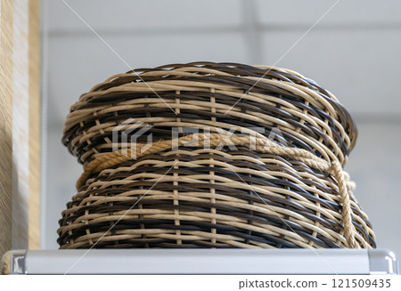 Wicker basket made of brown and yellow rods. 121509435