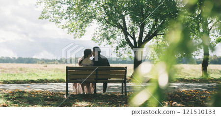 Couple sitting on a park bench (marriage, wedding, bridal) Couple sitting on a park bench (marriage, wedding, bridal) 121510133