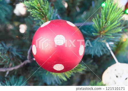 Red ornaments on a Christmas tree - festive decoration Red ornaments on a Christmas tree - festive decoration 121510171