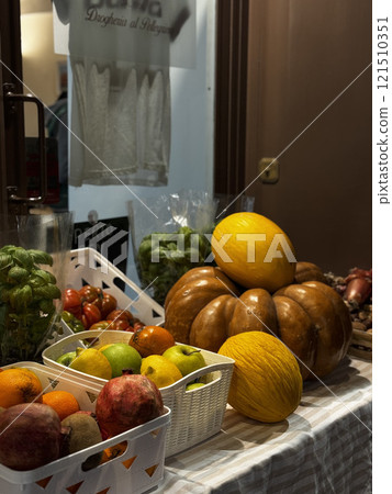 A variety of fresh fruits and vegetables are arranged neatly at a market stall during the evening. The scene captures the vibrancy of local produce and the inviting atmosphere. A variety of fresh fruits and vegetables are arranged neatly at a market stall during the evening. The scene captures the vibrancy of local produce and the inviting atmosphere. 121510351