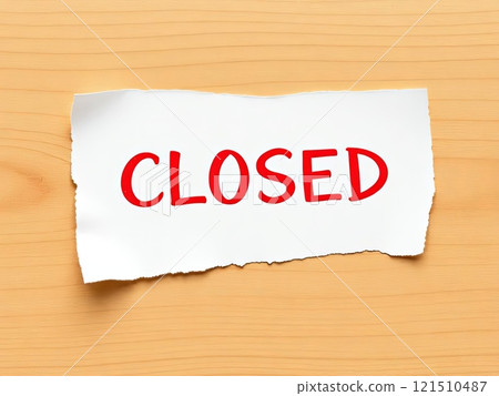 A piece of torn paper that clearly has the word closed written on it in a bold and prominent manner, effectively conveying its message 121510487