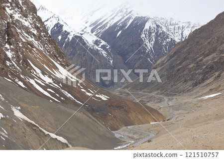 一條穿過被殘雪覆蓋的山谷的道路（四月巴基斯坦北部） 121510757