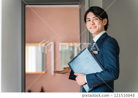 A businessman guiding guests to hotels and real estate (advisor, planner, hotelier) A businessman guiding guests to hotels and real estate (advisor, planner, hotelier) 121510848