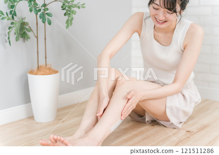 Asian woman who sticks a tree sheet to prevent swelling on her legs and calves (foot care) Asian woman who sticks a tree sheet to prevent swelling on her legs and calves (foot care) 121511286